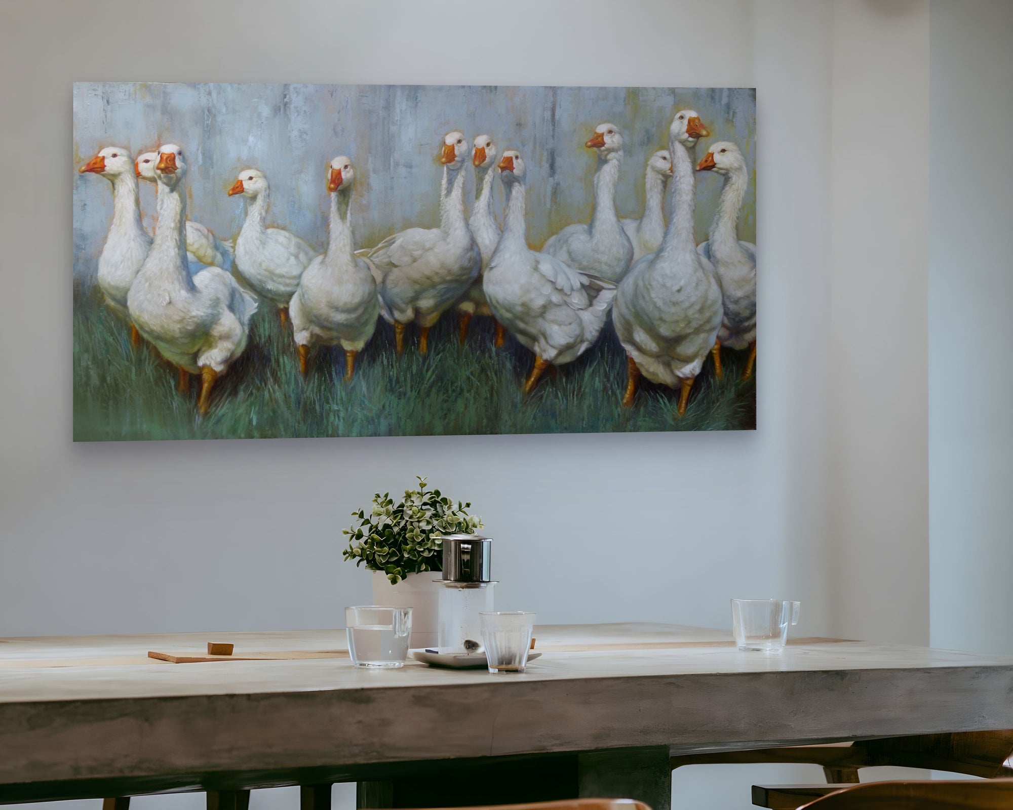 Framed artwork of geese on a wall above a dining table.